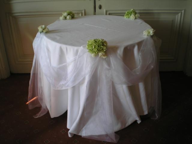 Brompton Floral Designs Wedding Flowers Central London UK NW4 A decorated cake table with white organza, white Akito Roses and Hydrangeas. 